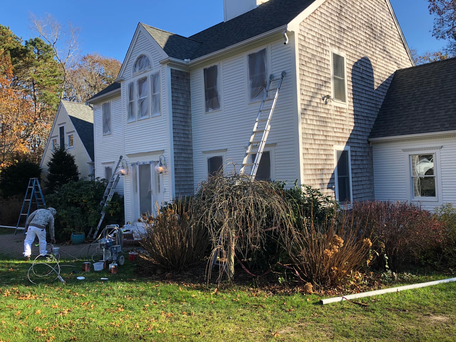 White 1920s Cape Cod colonial during a full exterior repaint in Falmouth